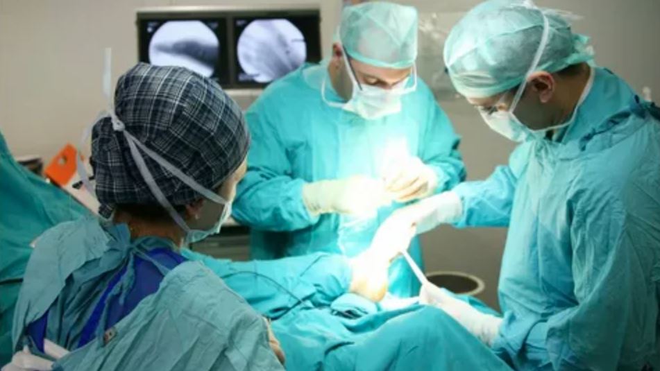 Surgeons conducting a surgical procedure in a sterile operating room, focused on patient care and precision.