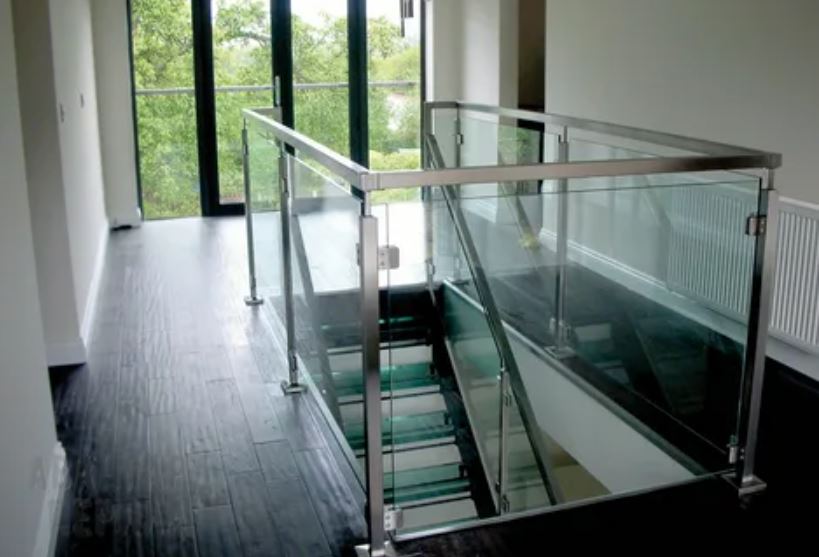 A sleek glass stair railing enhances the contemporary design of a modern home interior.